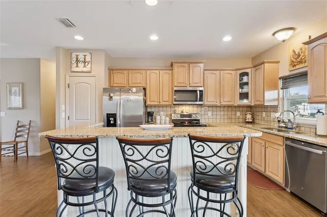 a kitchen with stainless steel appliances granite countertop a table and chairs