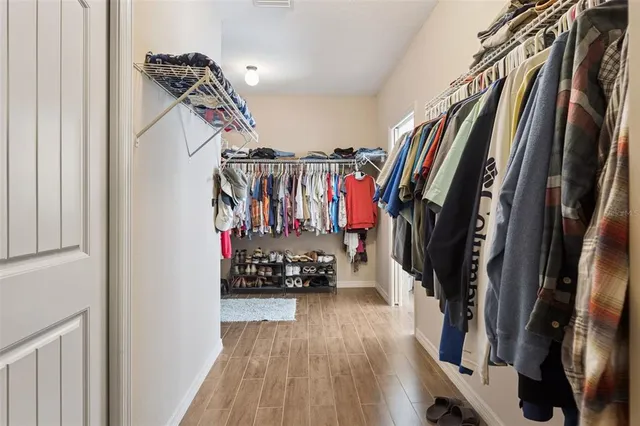 a view of walk in closet with clothes and shoes