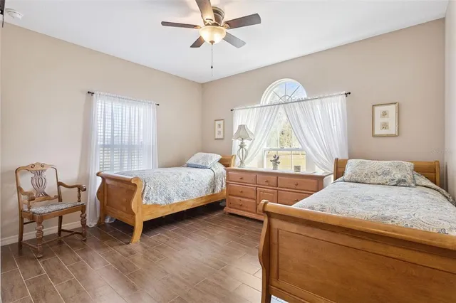a bedroom with a bed a chair and a chandelier