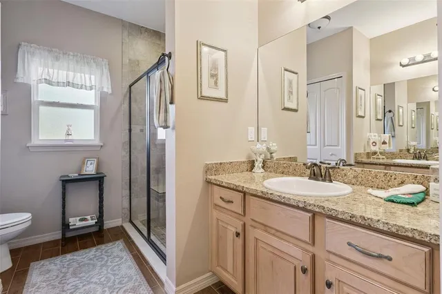 a spacious bathroom with a granite countertop sink mirror and a toilet