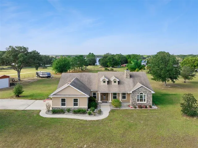 a view of a big house with a big yard and potted plants