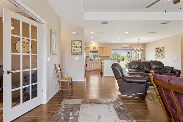 a living room with furniture a rug kitchen view and a large window