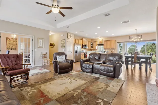 a living room with furniture kitchen view and a large window