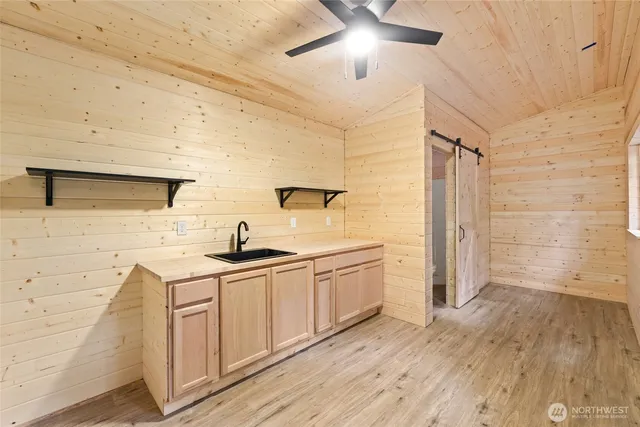 a kitchen with stainless steel appliances a sink cabinets and wooden floor