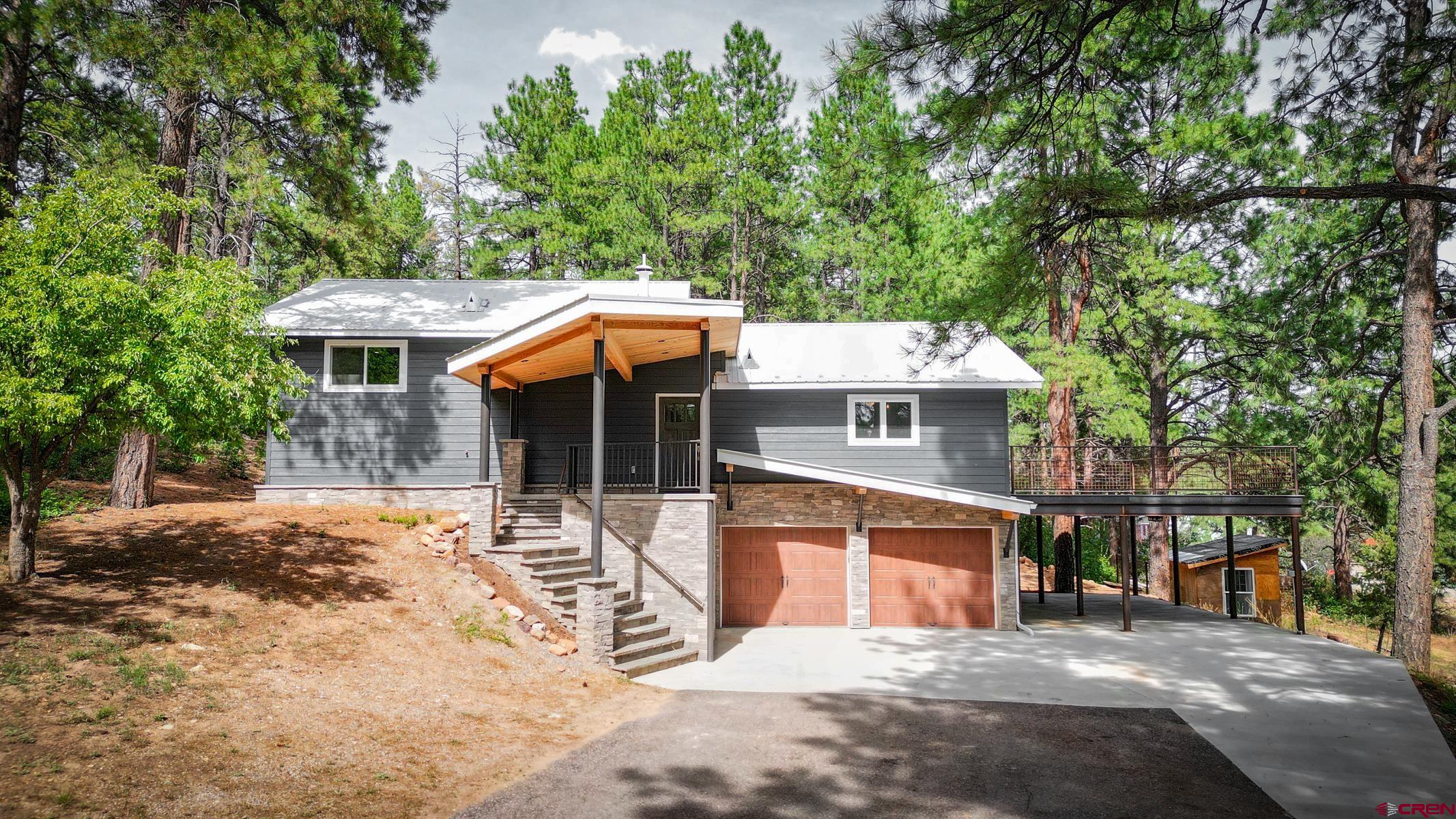 a front view of a house with a yard garage and a tree
