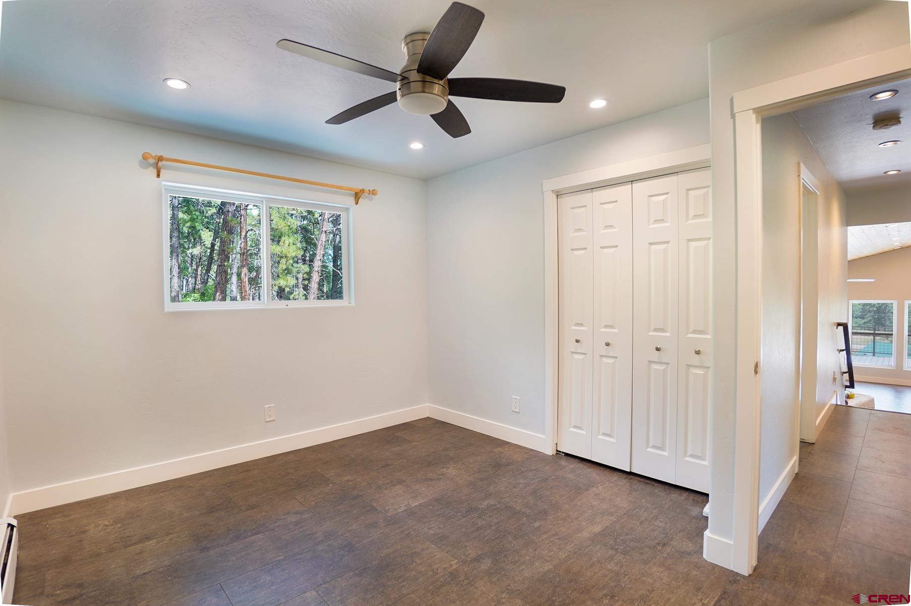 120 Sortais Road Durango, CO 81301 - Photo 13 of 21 an empty room with windows and a ceiling fan