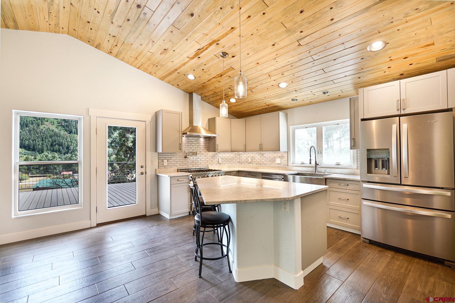 120 Sortais Road Durango, CO 81301 - Photo 5 of 21 a kitchen with a refrigerator a sink dishwasher a stove and white cabinets with wooden floor