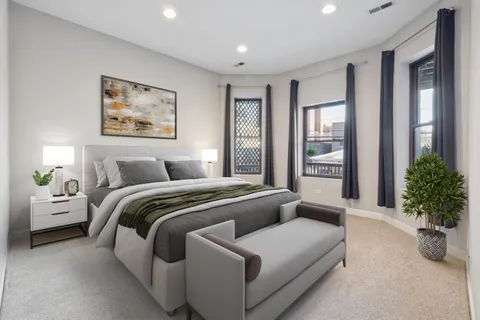 a spacious bedroom with a balcony a bed and a potted plant