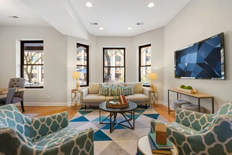 a living room with furniture a flat screen tv and a window