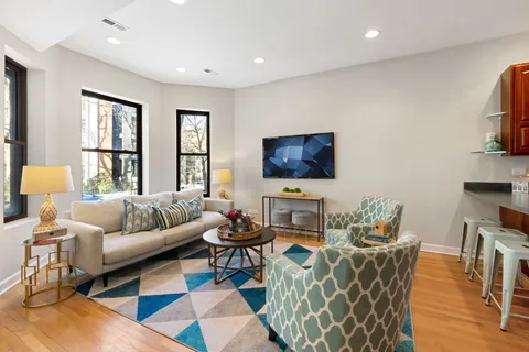 a living room with furniture a flat screen tv and a window