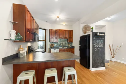 a kitchen with stainless steel appliances granite countertop a refrigerator a sink a stove and island