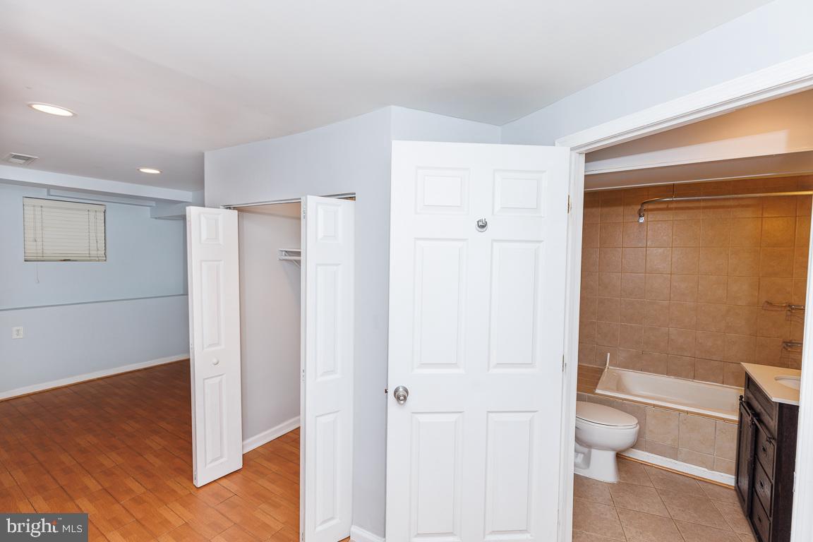 1437 East Capitol Street Southeast, Unit B Washington, DC 20003 - Photo 16 of 20 a bathroom with a granite countertop toilet a sink and a mirror