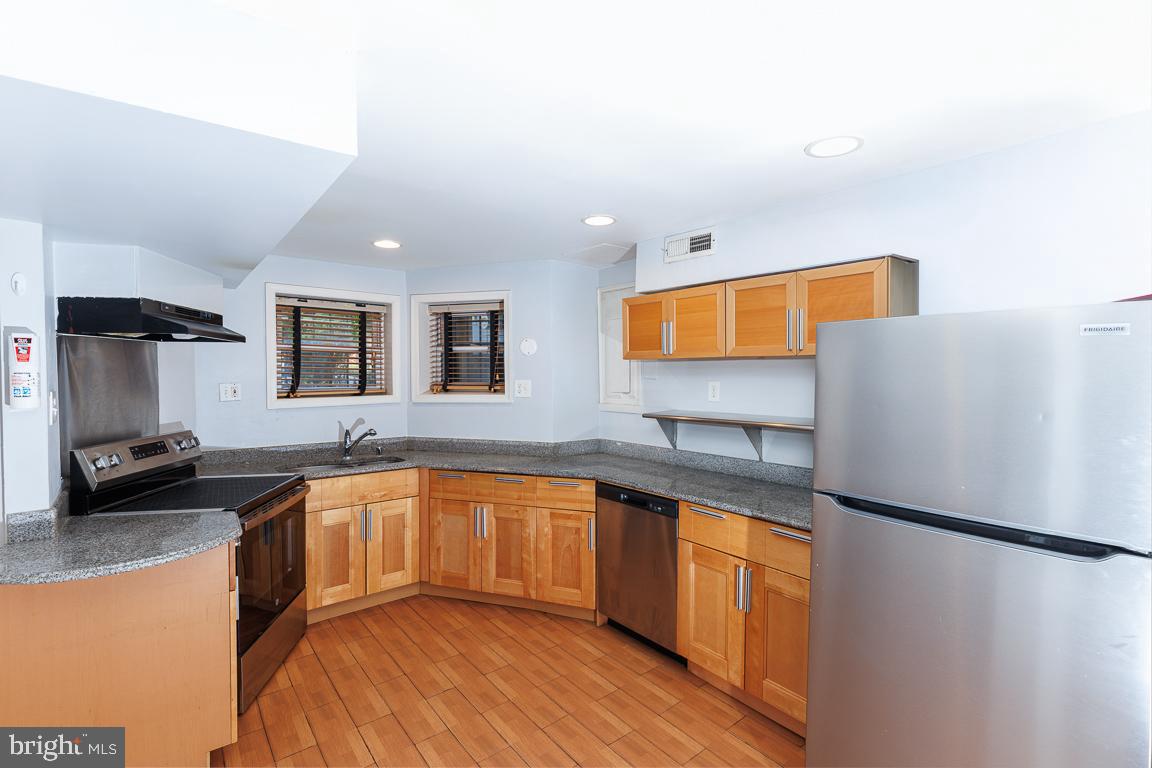 1437 East Capitol Street Southeast, Unit B Washington, DC 20003 - Photo 8 of 20 a kitchen with stainless steel appliances granite countertop a sink stove and refrigerator