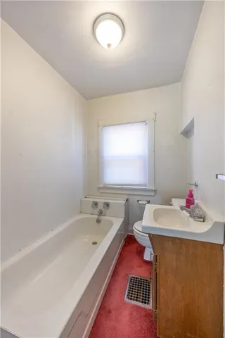 a bathroom with a bathtub sink vanity and mirror