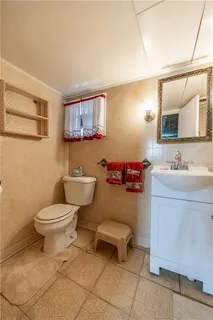 a bathroom with a toilet a sink and a mirror