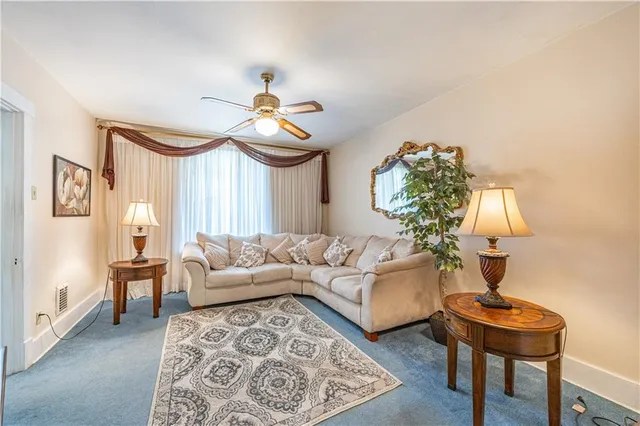 a living room with furniture a chandelier and a window