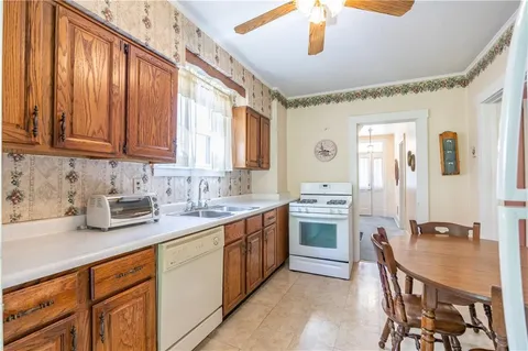 a kitchen with stainless steel appliances granite countertop a sink dishwasher stove and refrigerator with wooden cabinets