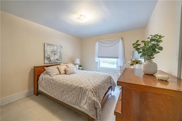 a bedroom with a bed potted plant on table and a window
