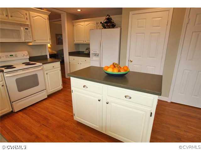 13904 Eastbluff Road Midlothian, VA 23112 - Photo 7 of 12 a kitchen with stainless steel appliances a stove a refrigerator and cabinets
