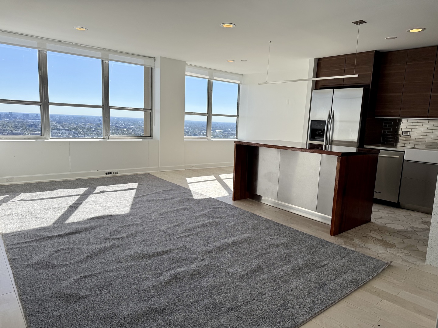 655 West Irving Park Road, Unit 5513 Chicago, IL 60613 - Photo 2 of 17 a kitchen with stainless steel appliances granite countertop a refrigerator a stove and a sink with wooden cabinets