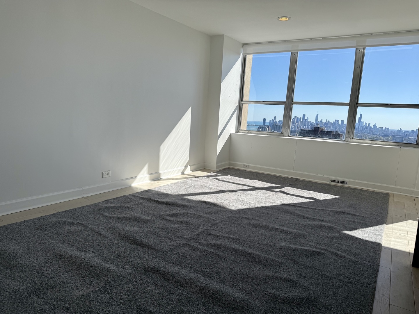 655 West Irving Park Road, Unit 5513 Chicago, IL 60613 - Photo 4 of 17 a view of empty room with wooden floor and fan