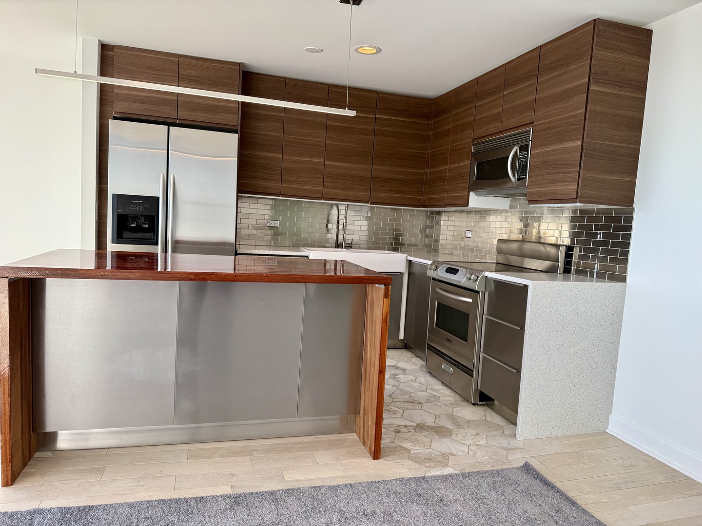 655 West Irving Park Road, Unit 5513 Chicago, IL 60613 - Photo 7 of 17 a kitchen with stainless steel appliances granite countertop a stove a sink and a microwave