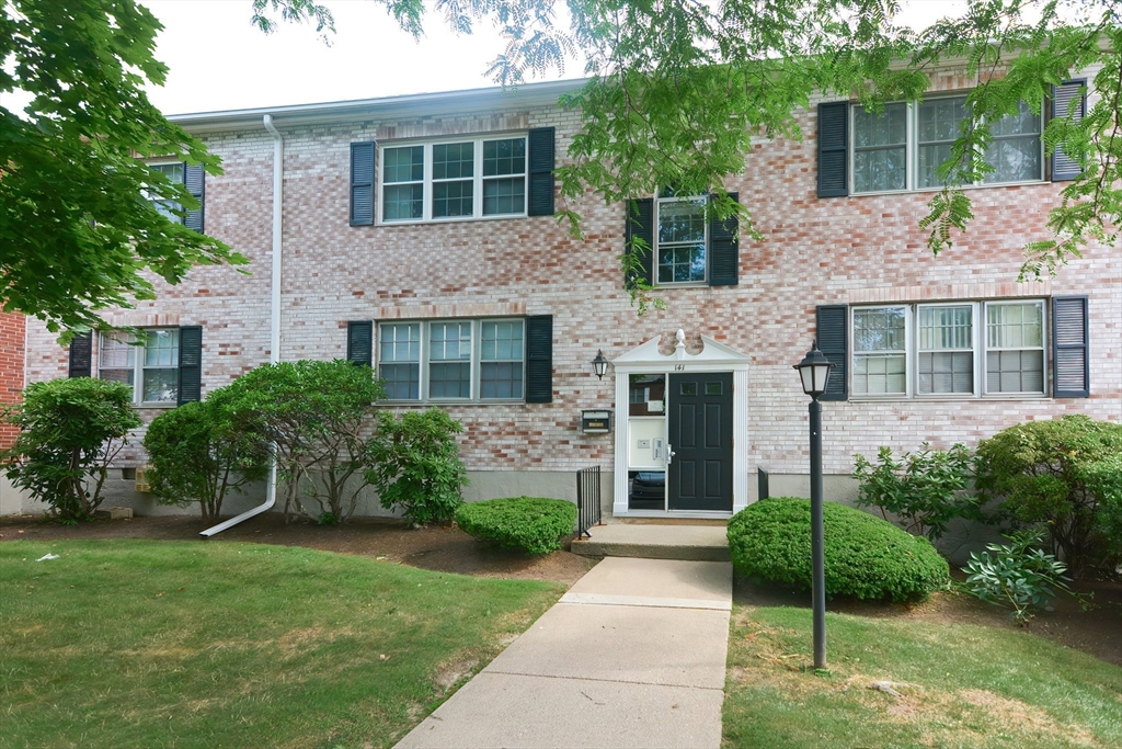 141 Lake Shore Road, Unit 1 Boston, MA 02135 - Photo 3 of 42 a front view of a house with a garden and yard
