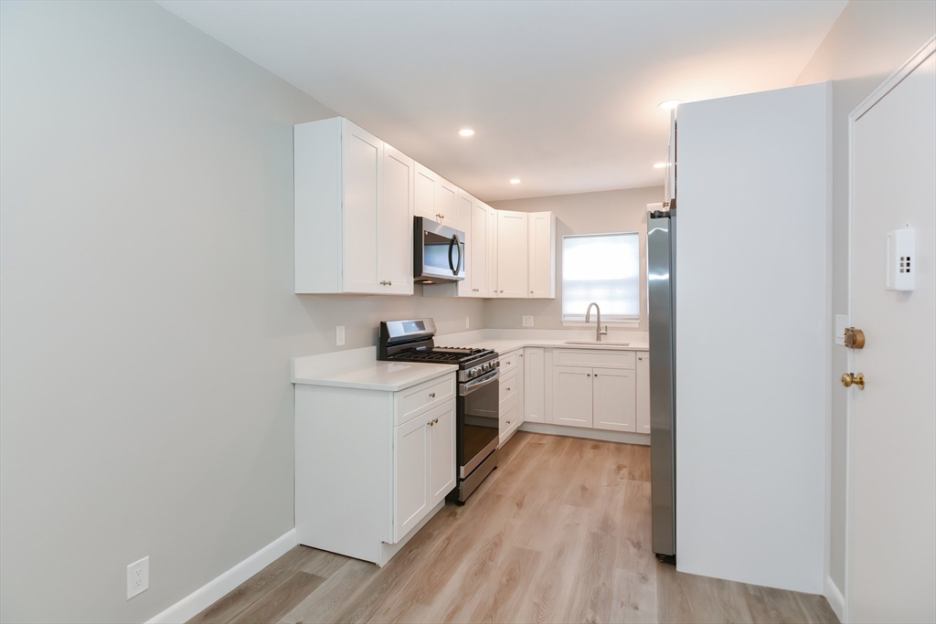141 Lake Shore Road, Unit 1 Boston, MA 02135 - Photo 5 of 42 a kitchen with a white stove top oven and refrigerator