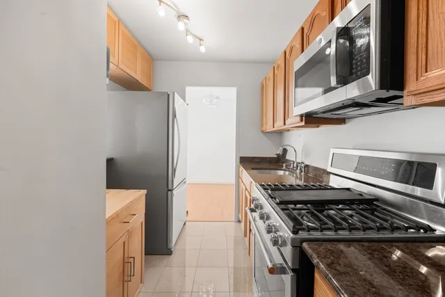 a kitchen with stainless steel appliances granite countertop a stove and a microwave