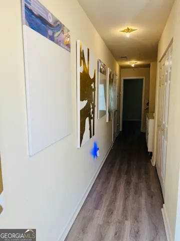 a view of a hallway with wooden floor