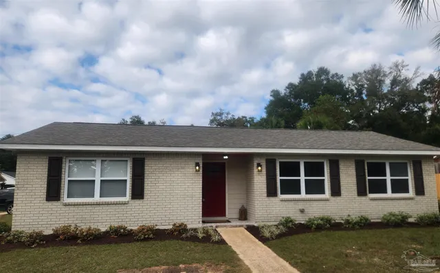 a front view of a house with garden and yard