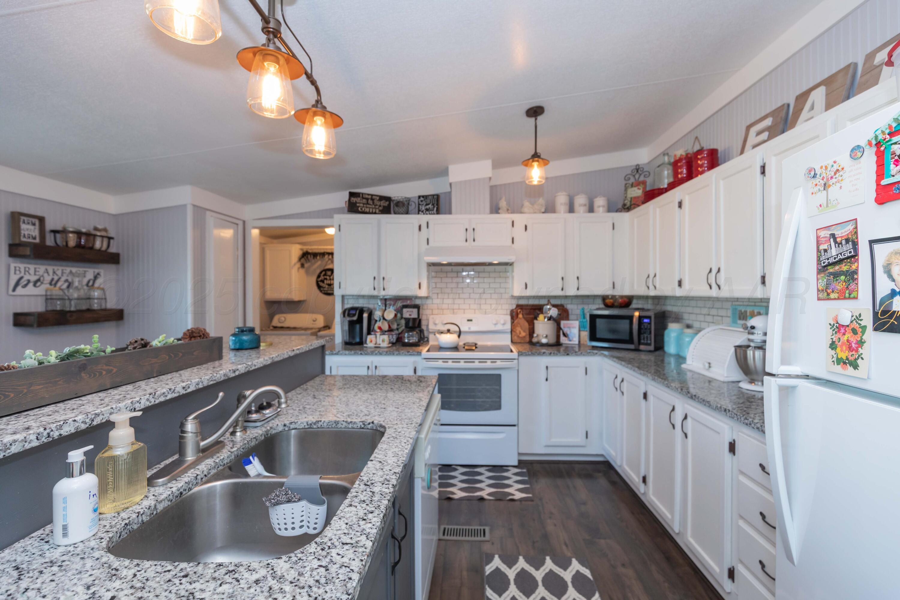 7501 Lobo Trail Amarillo, TX 79124 - Photo 15 of 49 a kitchen with kitchen island granite countertop a sink stainless steel appliances and cabinets