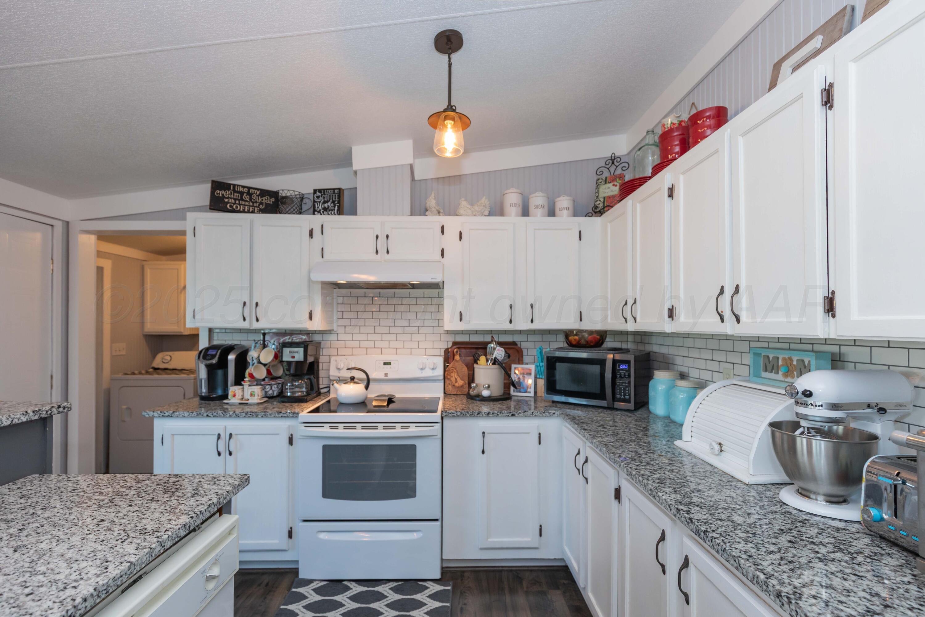 7501 Lobo Trail Amarillo, TX 79124 - Photo 16 of 49 a kitchen with granite countertop a sink a counter space appliances and cabinets