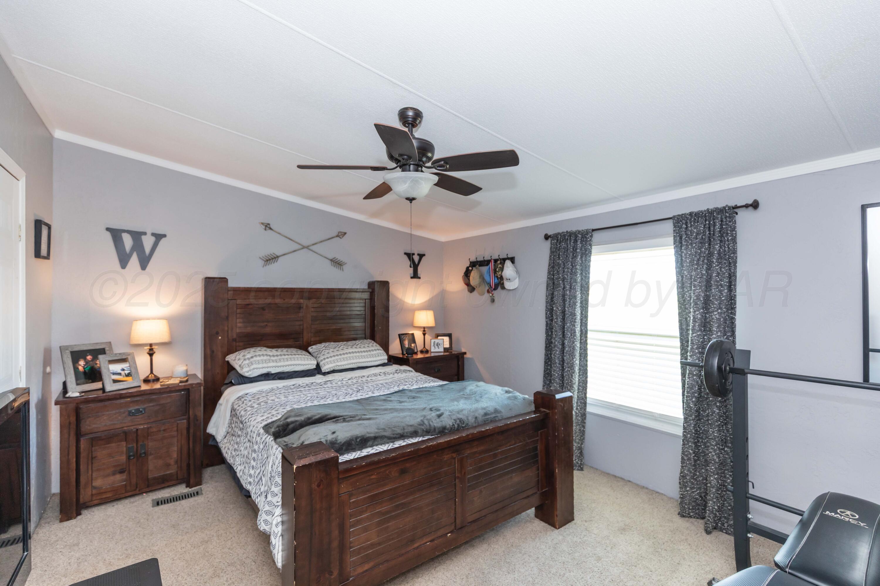 7501 Lobo Trail Amarillo, TX 79124 - Photo 20 of 49 a bed room with a bed and a ceiling fan