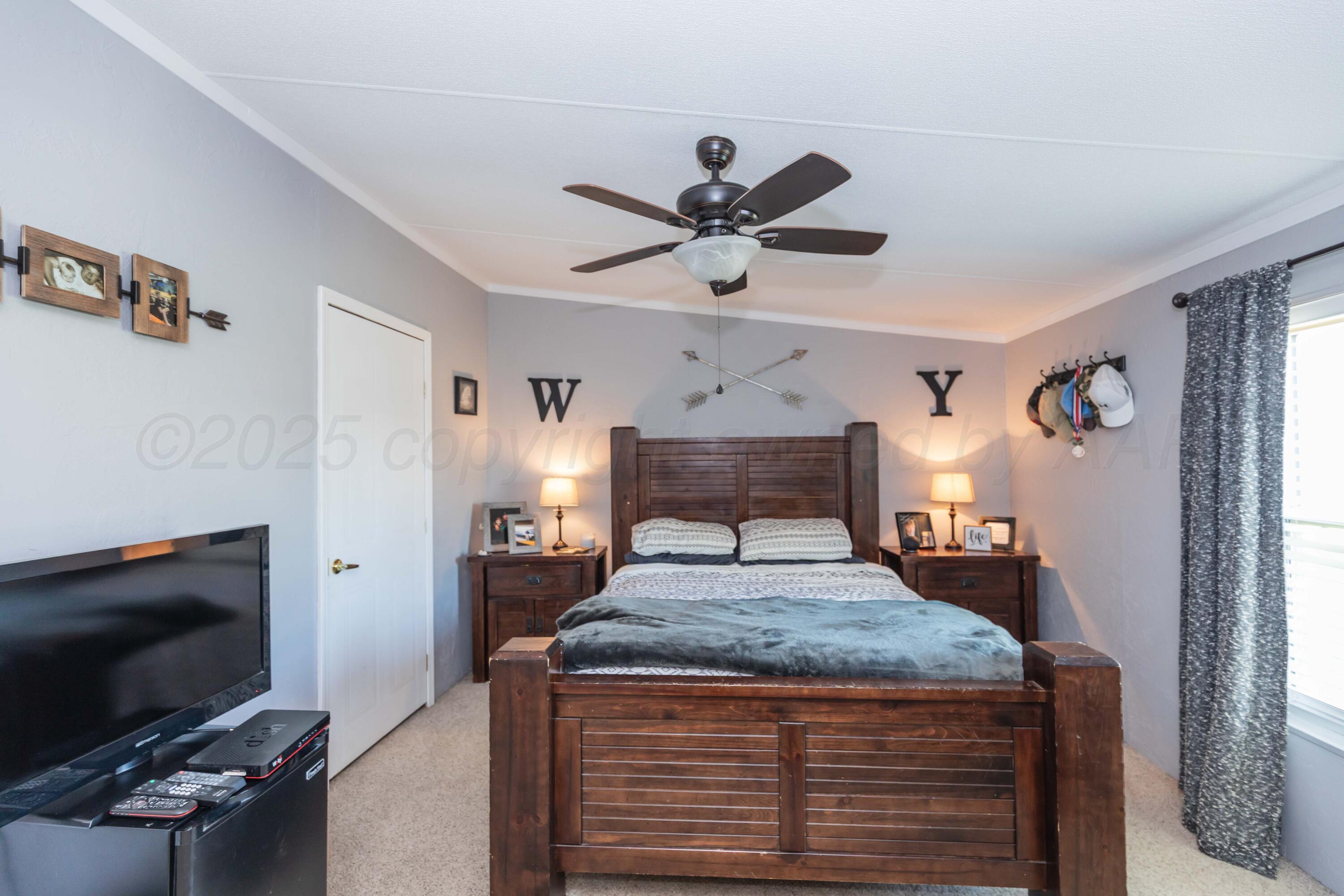 7501 Lobo Trail Amarillo, TX 79124 - Photo 21 of 49 a bedroom with a bed and a flat screen tv