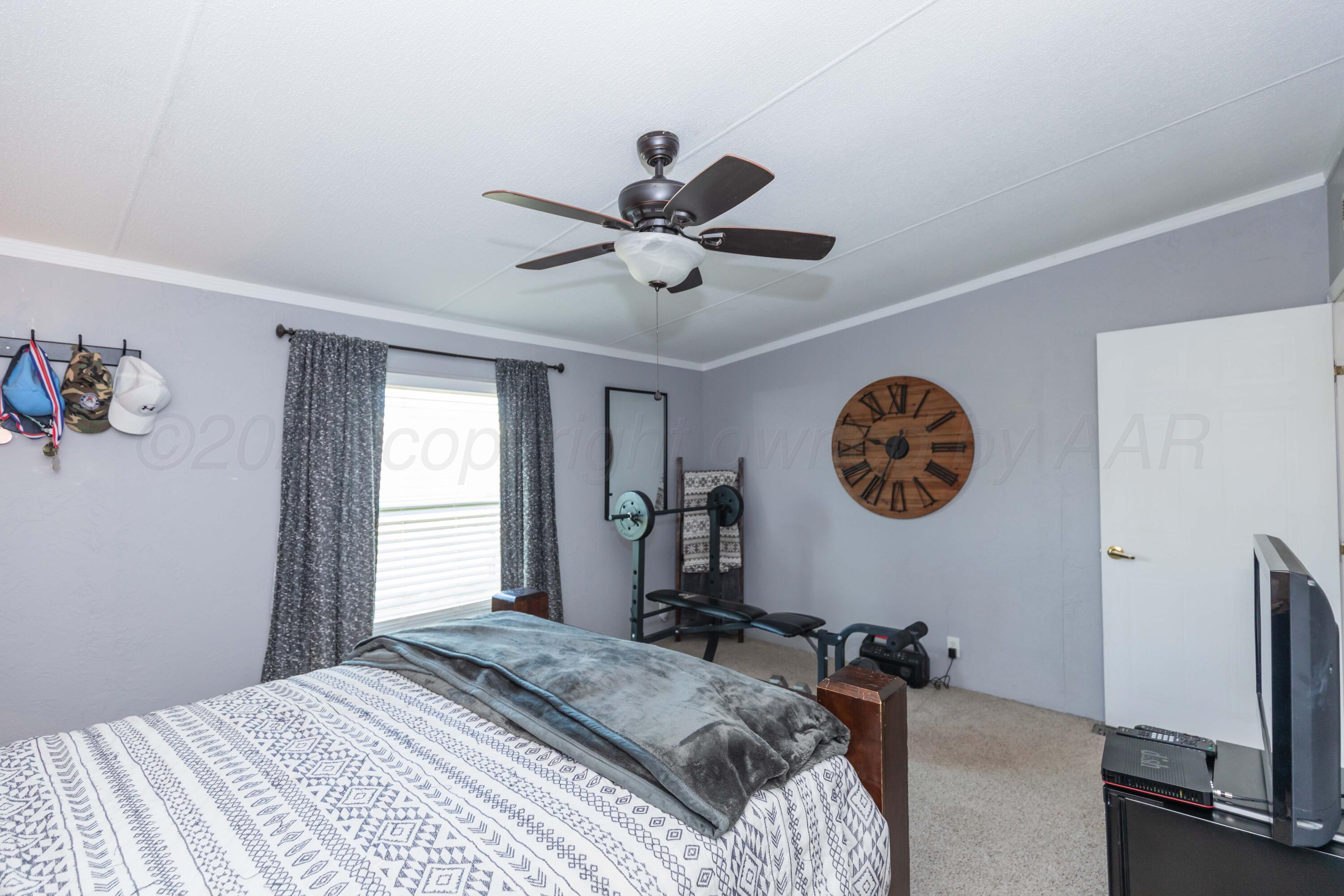 7501 Lobo Trail Amarillo, TX 79124 - Photo 22 of 49 a bedroom with a bed and a chandelier