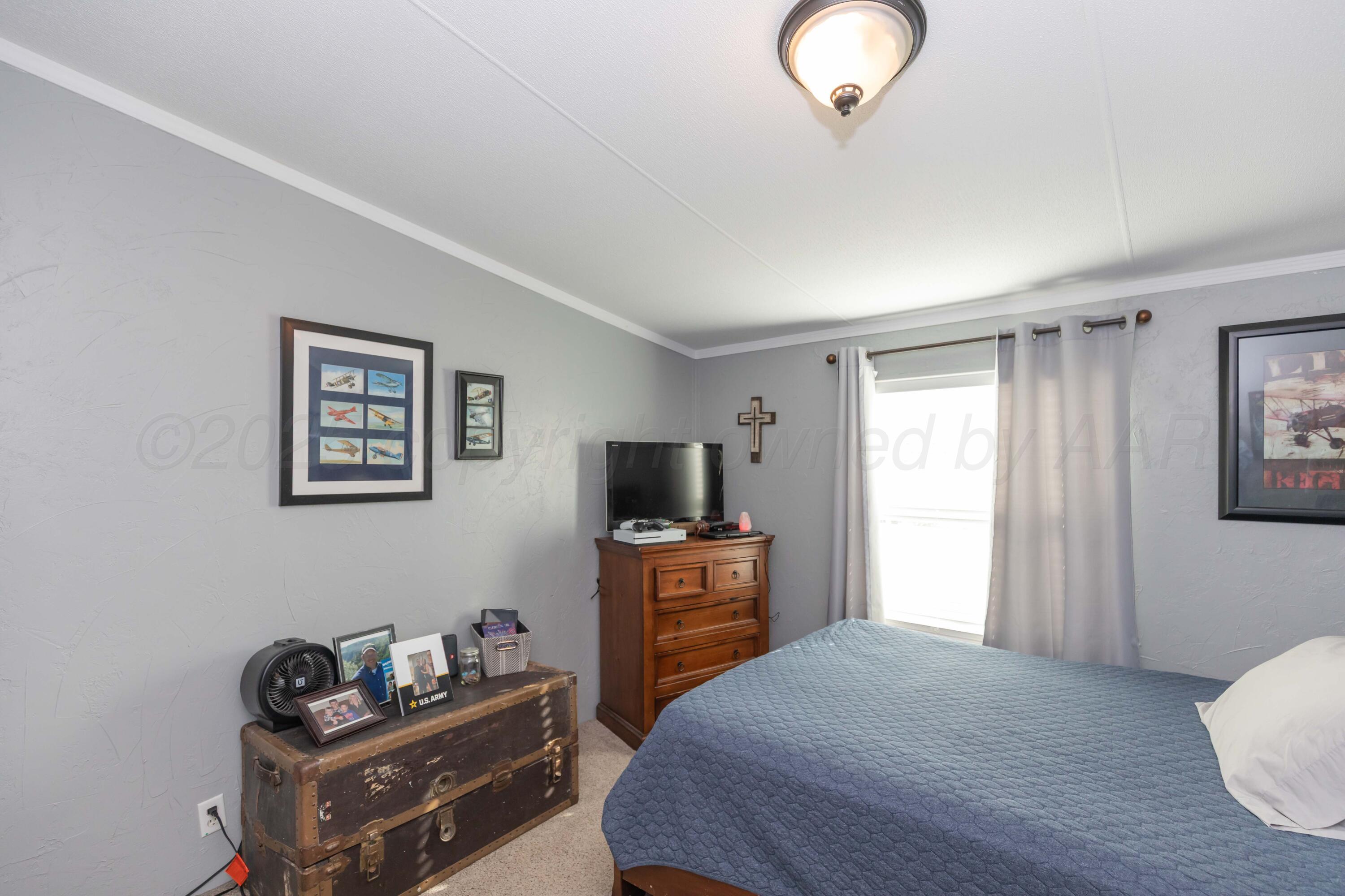 7501 Lobo Trail Amarillo, TX 79124 - Photo 25 of 49 a bedroom with a bed and wooden floor
