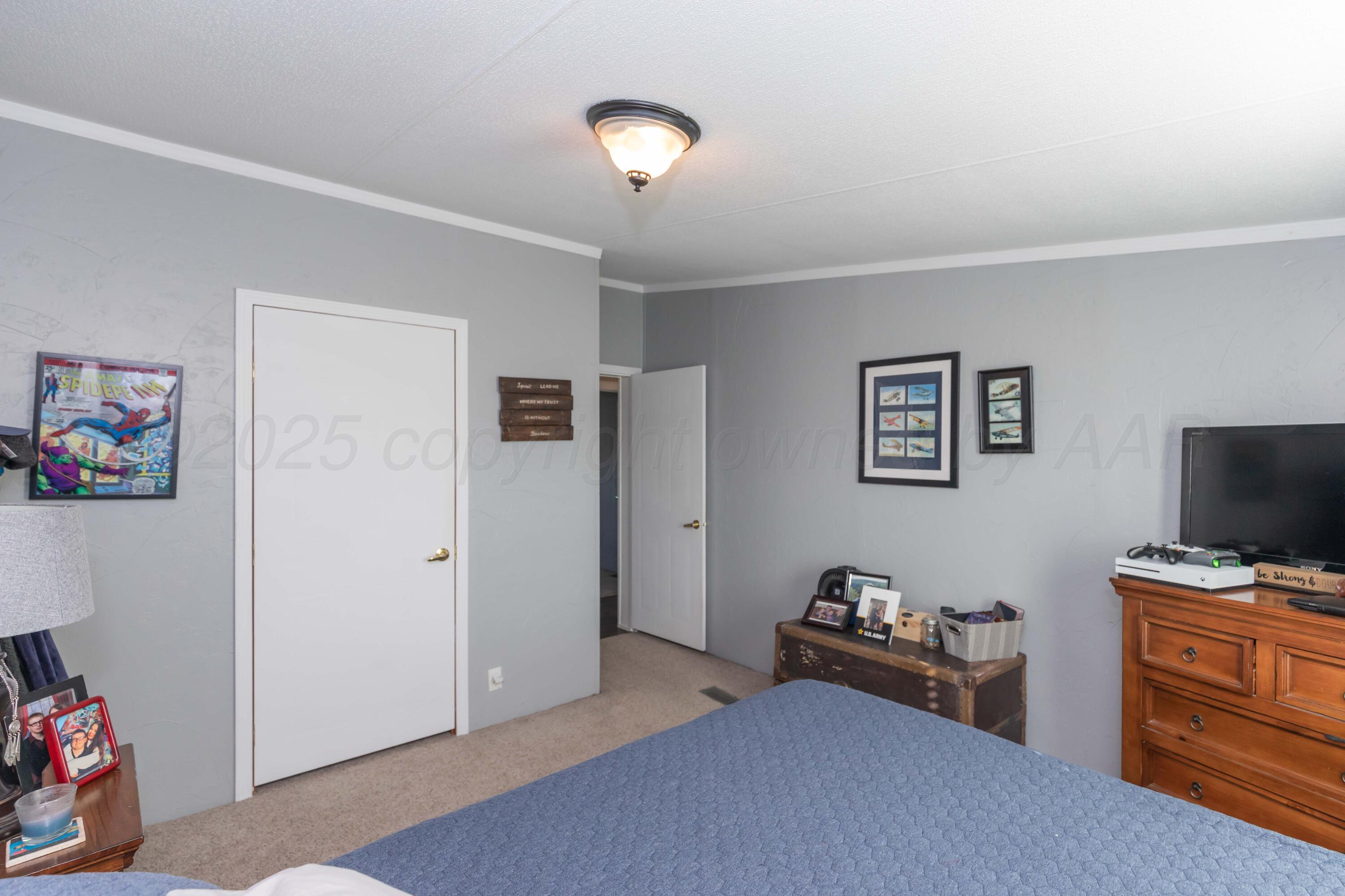 7501 Lobo Trail Amarillo, TX 79124 - Photo 26 of 49 a bedroom with furniture and a flat screen tv