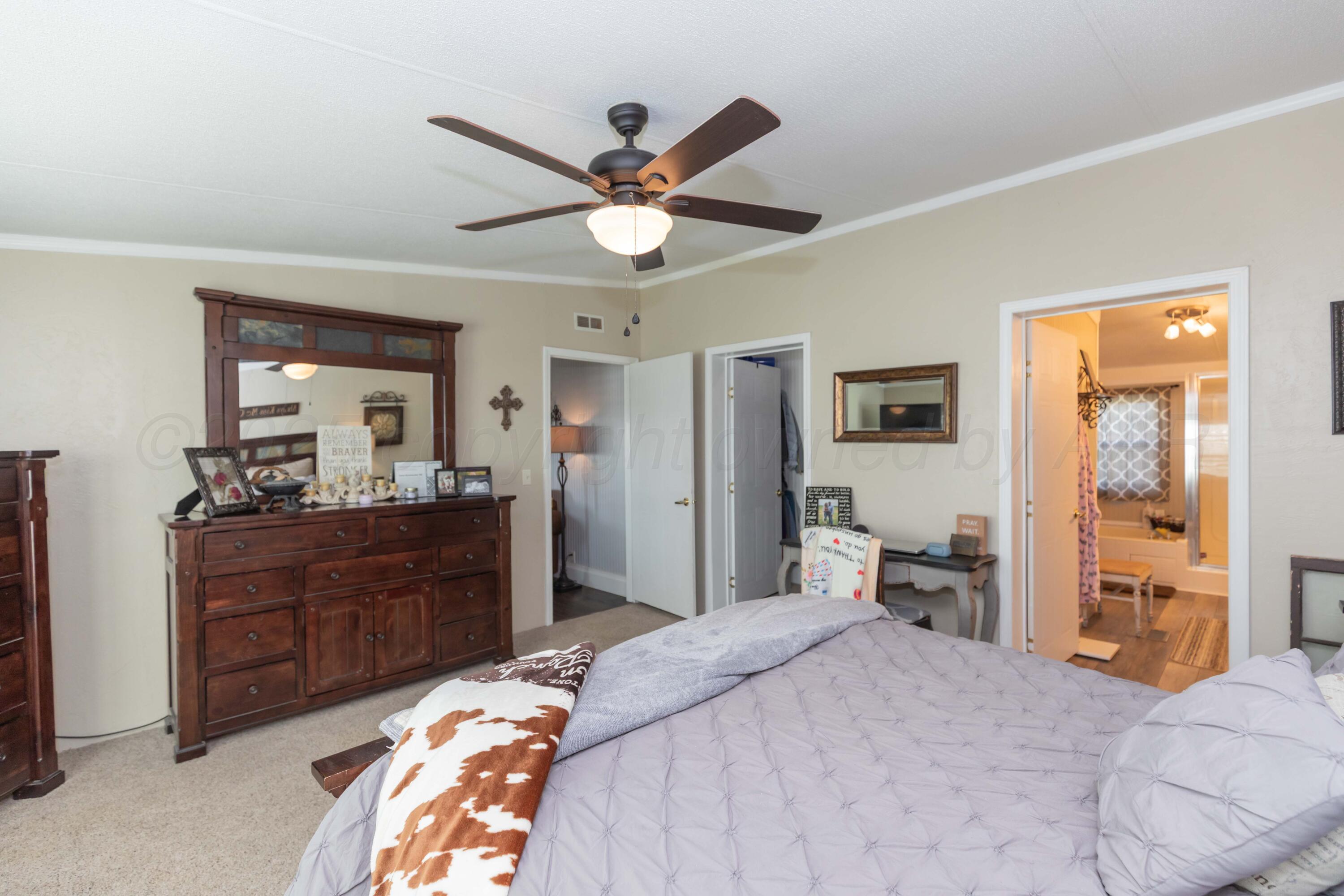 7501 Lobo Trail Amarillo, TX 79124 - Photo 35 of 49 a bedroom with a bed and a chandelier
