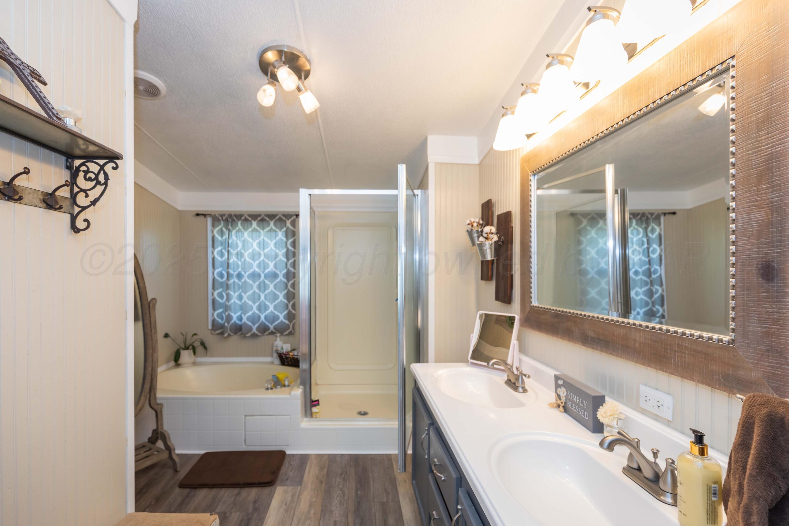 7501 Lobo Trail Amarillo, TX 79124 - Photo 37 of 49 a bathroom with a tub sink and mirror