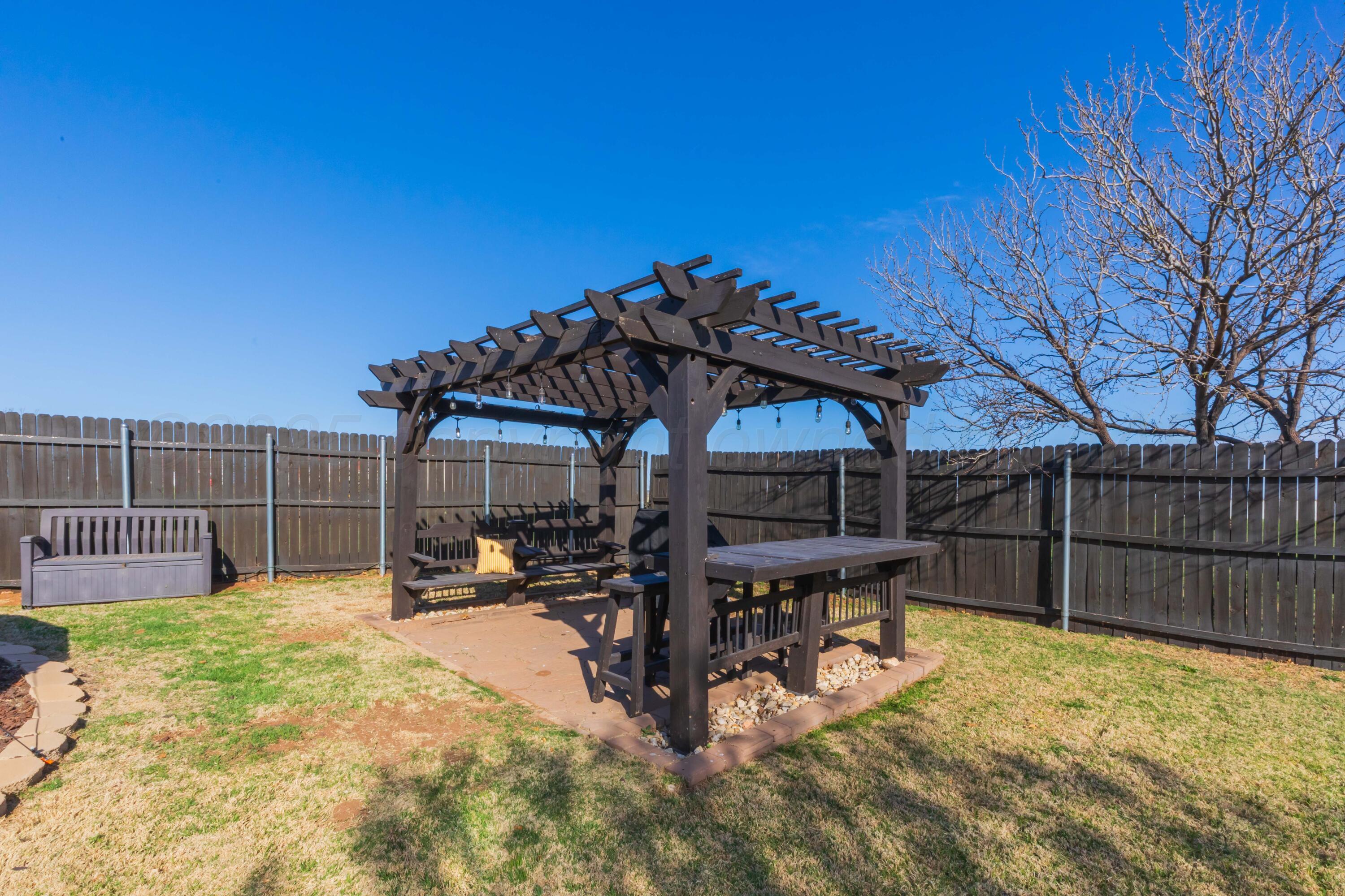 7501 Lobo Trail Amarillo, TX 79124 - Photo 44 of 49 a view of a patio with table and chairs with wooden fence and floor