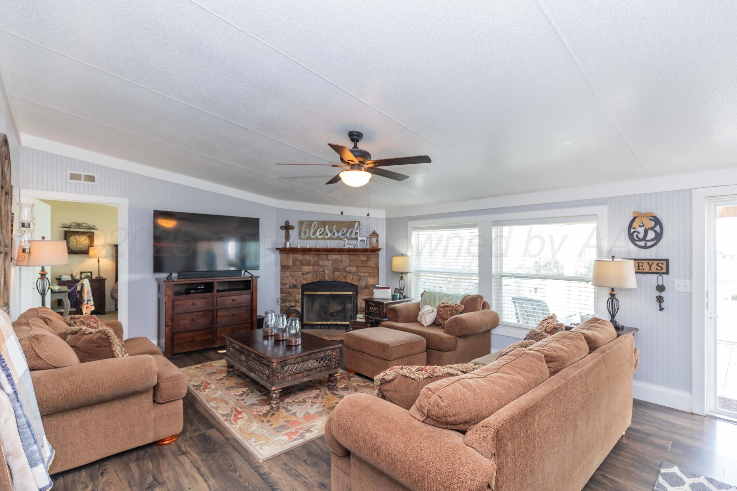 7501 Lobo Trail Amarillo, TX 79124 - Photo 8 of 49 a living room with furniture a fireplace and a flat screen tv