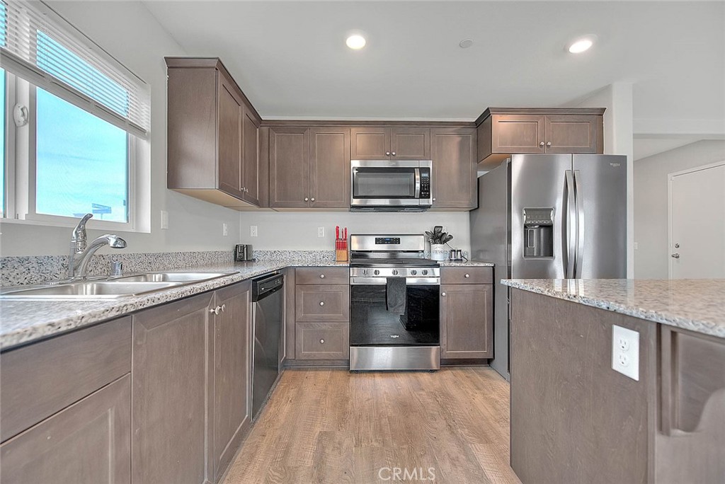 885 Canopy Lane San Jacinto, CA 92583 - Photo 49 of 75 a large kitchen with stainless steel appliances granite countertop a refrigerator a sink a stove top oven and a center island