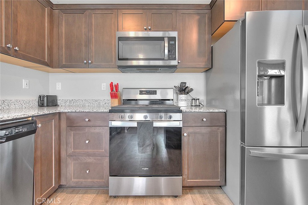 885 Canopy Lane San Jacinto, CA 92583 - Photo 50 of 75 a kitchen with stainless steel appliances granite countertop a stove a refrigerator and a microwave