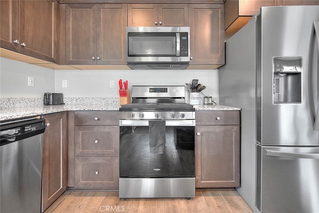 885 Canopy Lane San Jacinto, CA 92583 - Photo 53 of 75 a kitchen with stainless steel appliances granite countertop a stove a refrigerator and a sink
