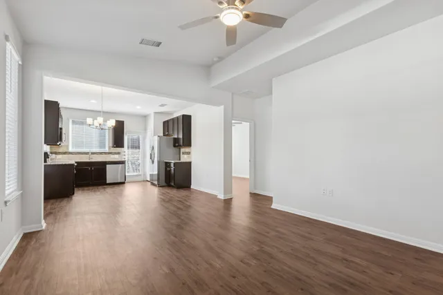 a view of a kitchen with a sink dishwasher a refrigerator with wooden floor and a kitchen