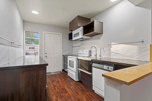 a kitchen with granite countertop a sink and a stove top oven