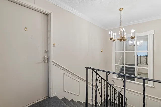 a view of a hallway with chandelier and entryway
