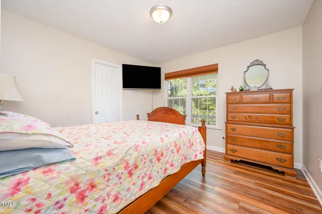 a bedroom with a bed and a flat screen tv