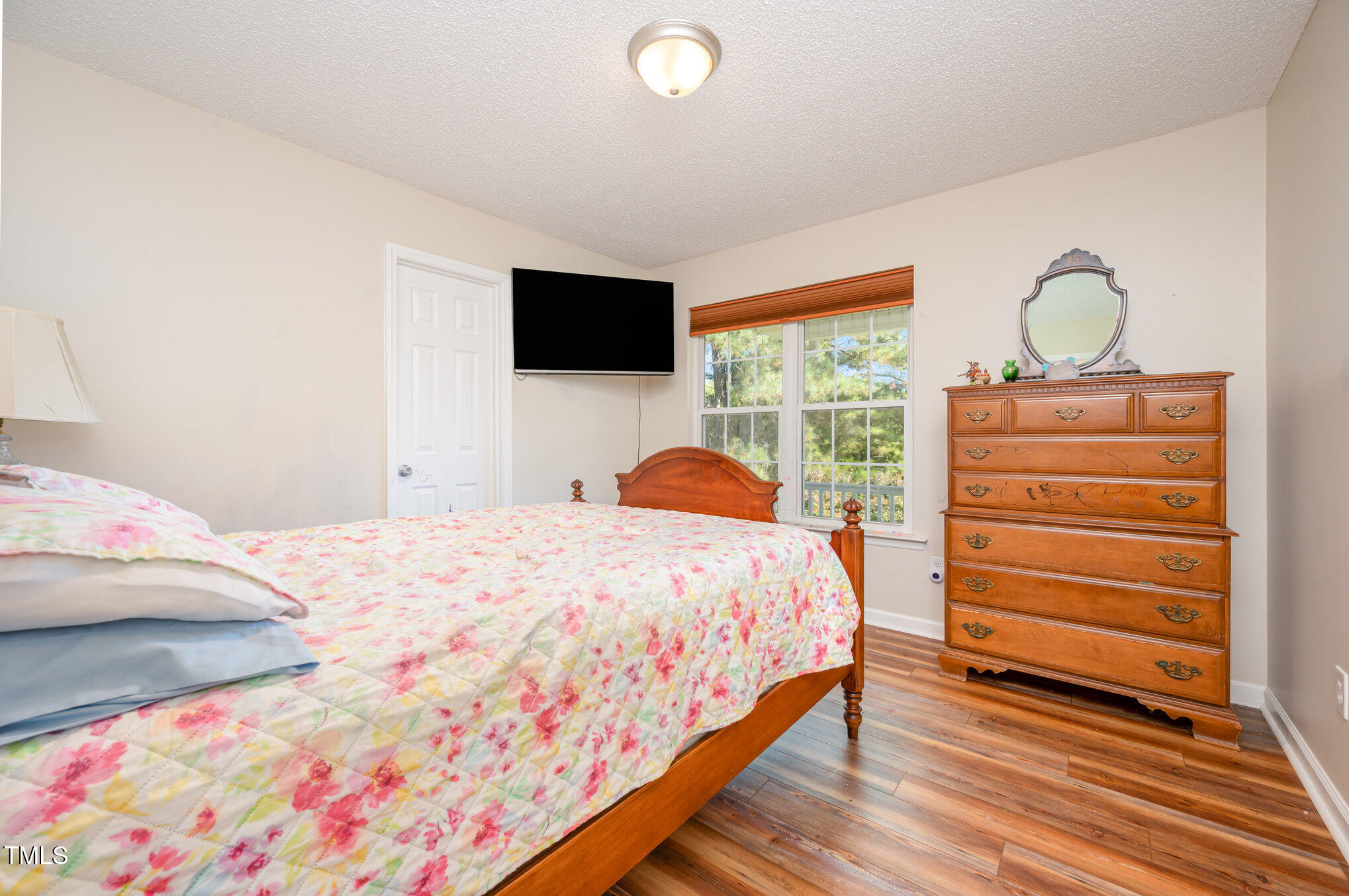 475 Jim Moore Road Timberlake, NC 27583 - Photo 13 of 26 a bedroom with a bed and a flat screen tv
